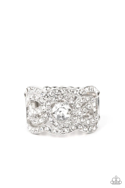 Paparazzi Accessories Doting On Dazzle - White Wavy scalloped rows encased with rhinestones are topped by a central, sparkling rhinestone to provide an elegant and timeless look. Features a stretchy band for a flexible fit. Sold as one individual ring. Je