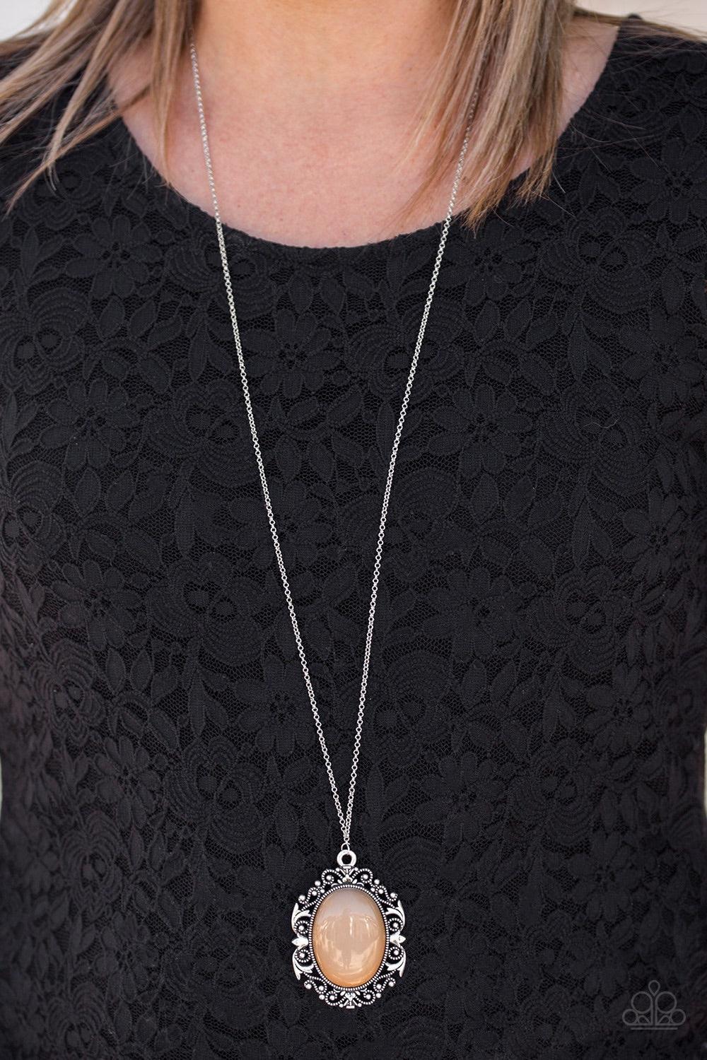 Paparazzi Accessories Vintage Vanity - Brown Featuring a faux rock finish, a shiny brown bead is pressed into the center of a frilly silver frame radiating with studded details. The dramatic pendant swings from the bottom of a lengthened silver chain for