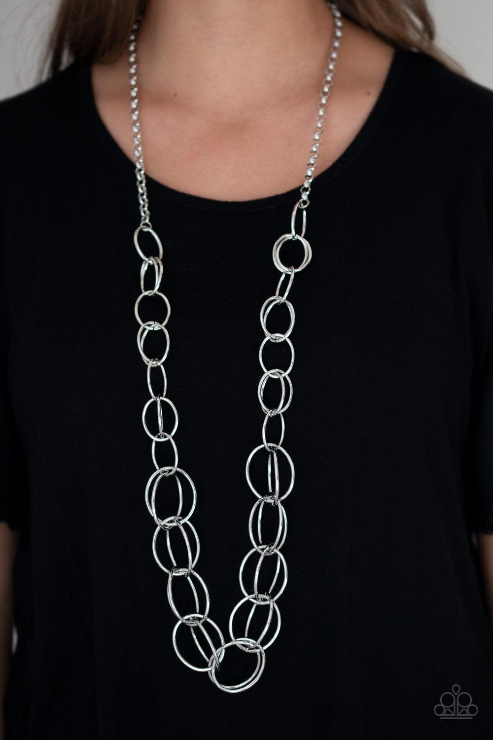 Paparazzi Accessories Elegantly Ensnared - Silver Gradually increasing in size, a collection of bold silver hoops link to a dramatically interconnected chain for a statement-making look. Features an adjustable clasp closure. Jewelry
