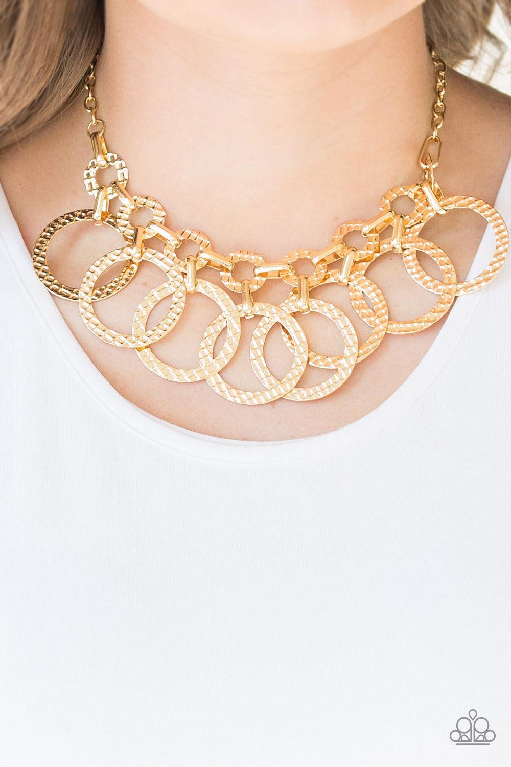 Paparazzi Accessories Jammin Jungle - Gold Hammered gold hoops swing from the bottom of interconnected hammered links, creating an edgy industrial fringe below the collar. Features an adjustable clasp closure. Sold as one individual necklace. Includes one