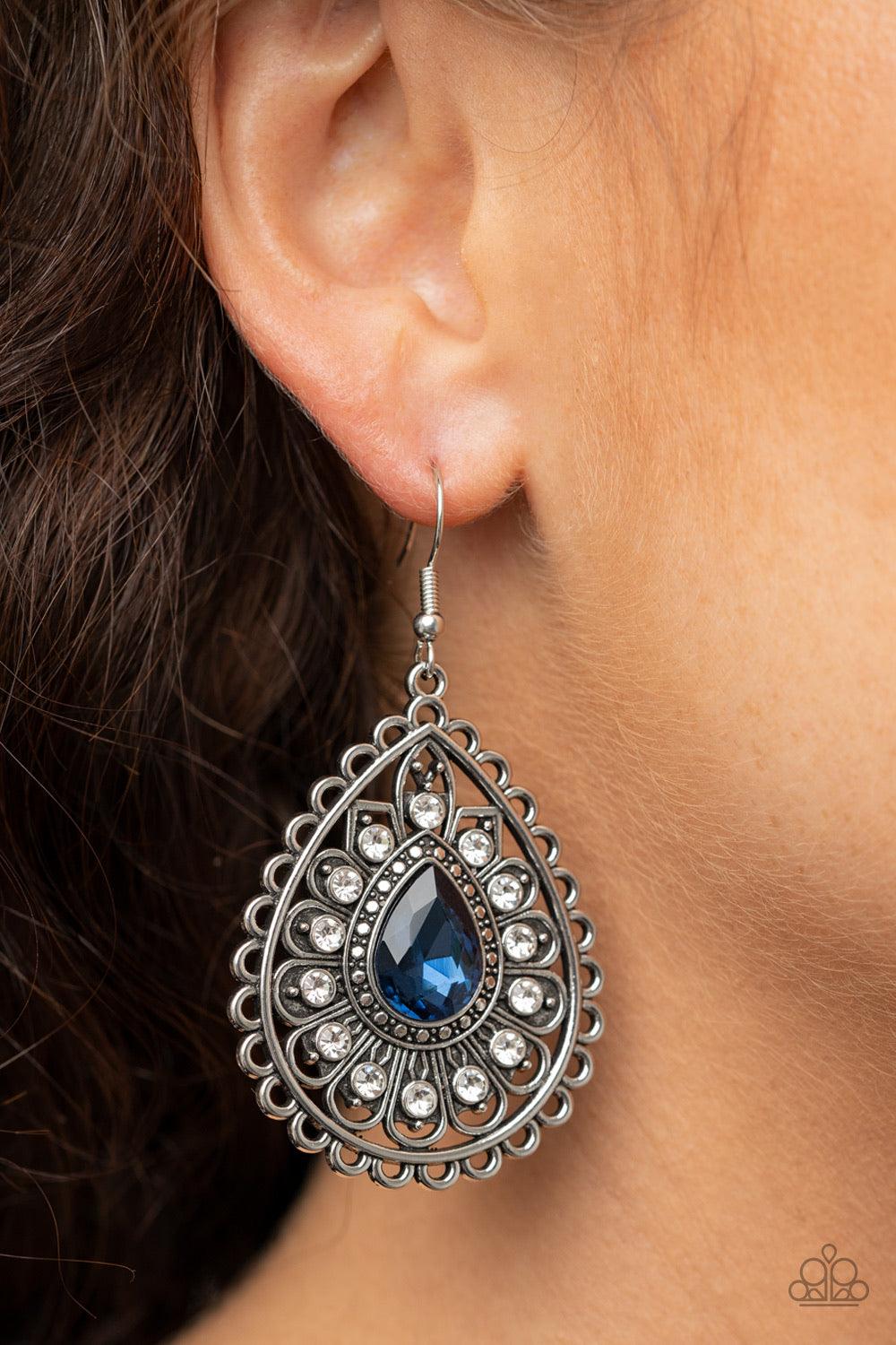 Paparazzi Accessories Eat, Drink, and BEAM Merry - Blue White rhinestone dotted silver petals flare out from a blue teardrop rhinestone center, coalescing into a frilly frame. Earring attaches to a standard fishhook fitting. Sold as one pair of earrings.
