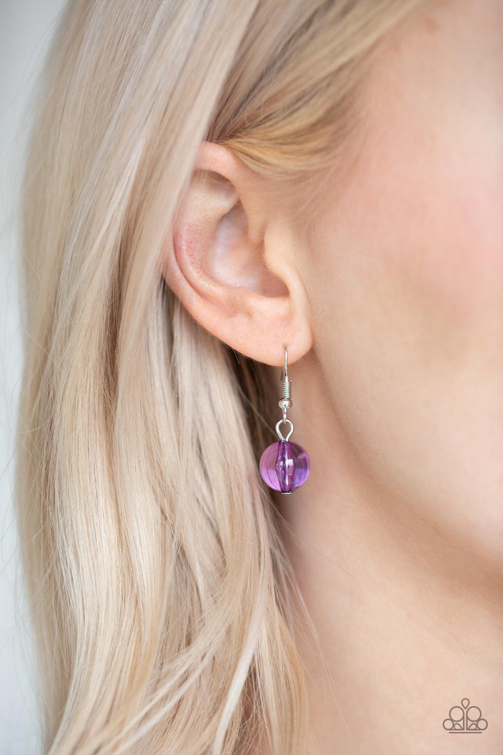 Paparazzi Accessories Crystal Charm - Purple A collection of glassy purple beads, shiny silver beads, and oversized faceted crystal-like beads trickle along a shimmery silver chain across the chest for a whimsically refined look. Features an adjustable cl