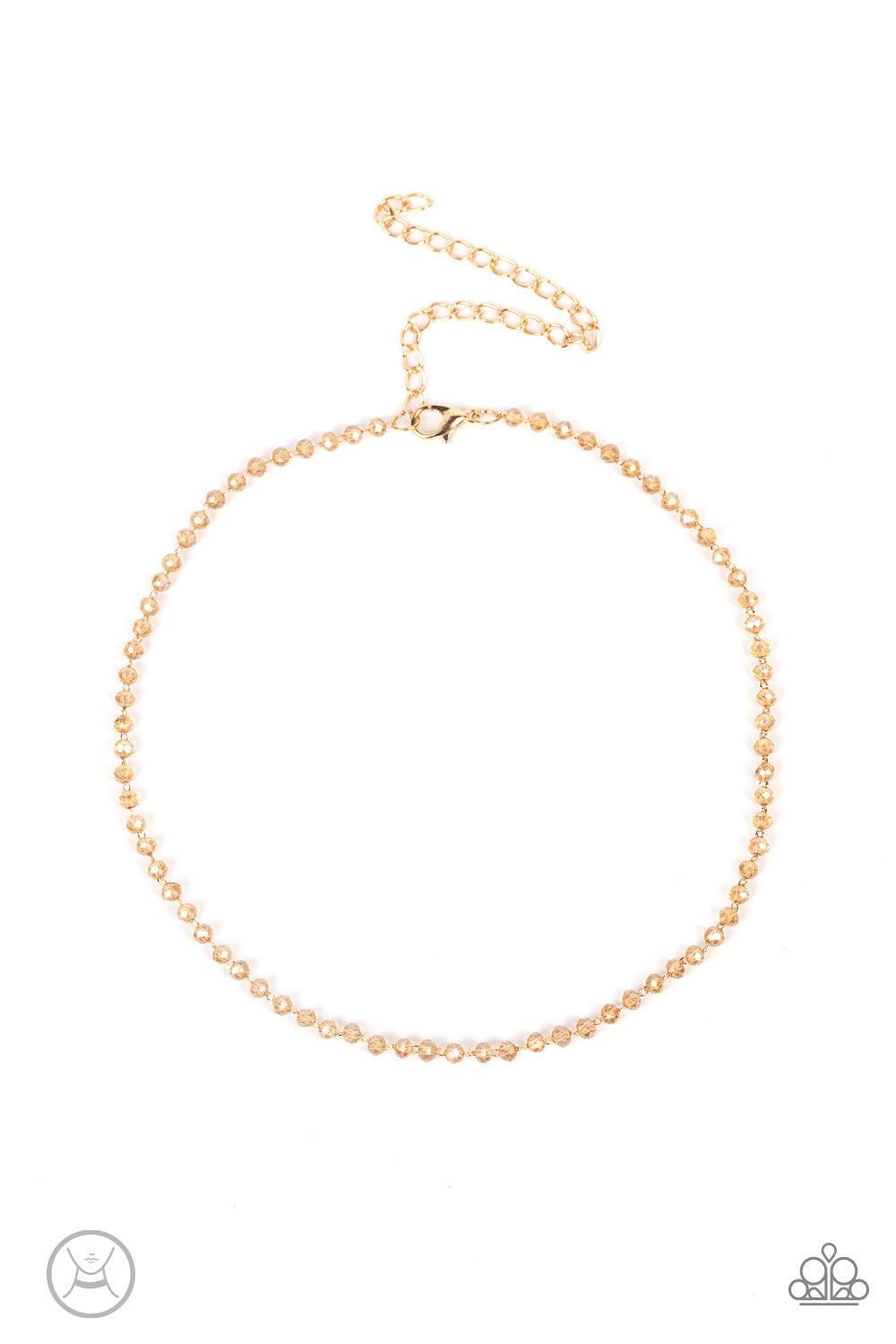 Paparazzi Accessories Mini MVP - Gold A dainty row of faceted white crystal-like beads delicately links around the neck, resulting in a golden glimmer. Features an adjustable clasp closure. Sold as one individual choker necklace. Includes one pair of matc
