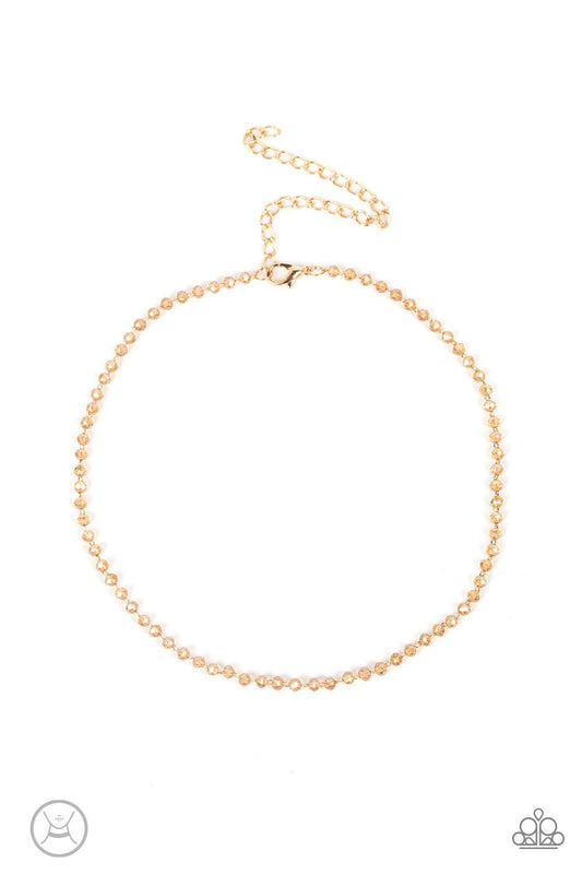 Paparazzi Accessories Mini MVP - Gold A dainty row of faceted white crystal-like beads delicately links around the neck, resulting in a golden glimmer. Features an adjustable clasp closure. Sold as one individual choker necklace. Includes one pair of matc