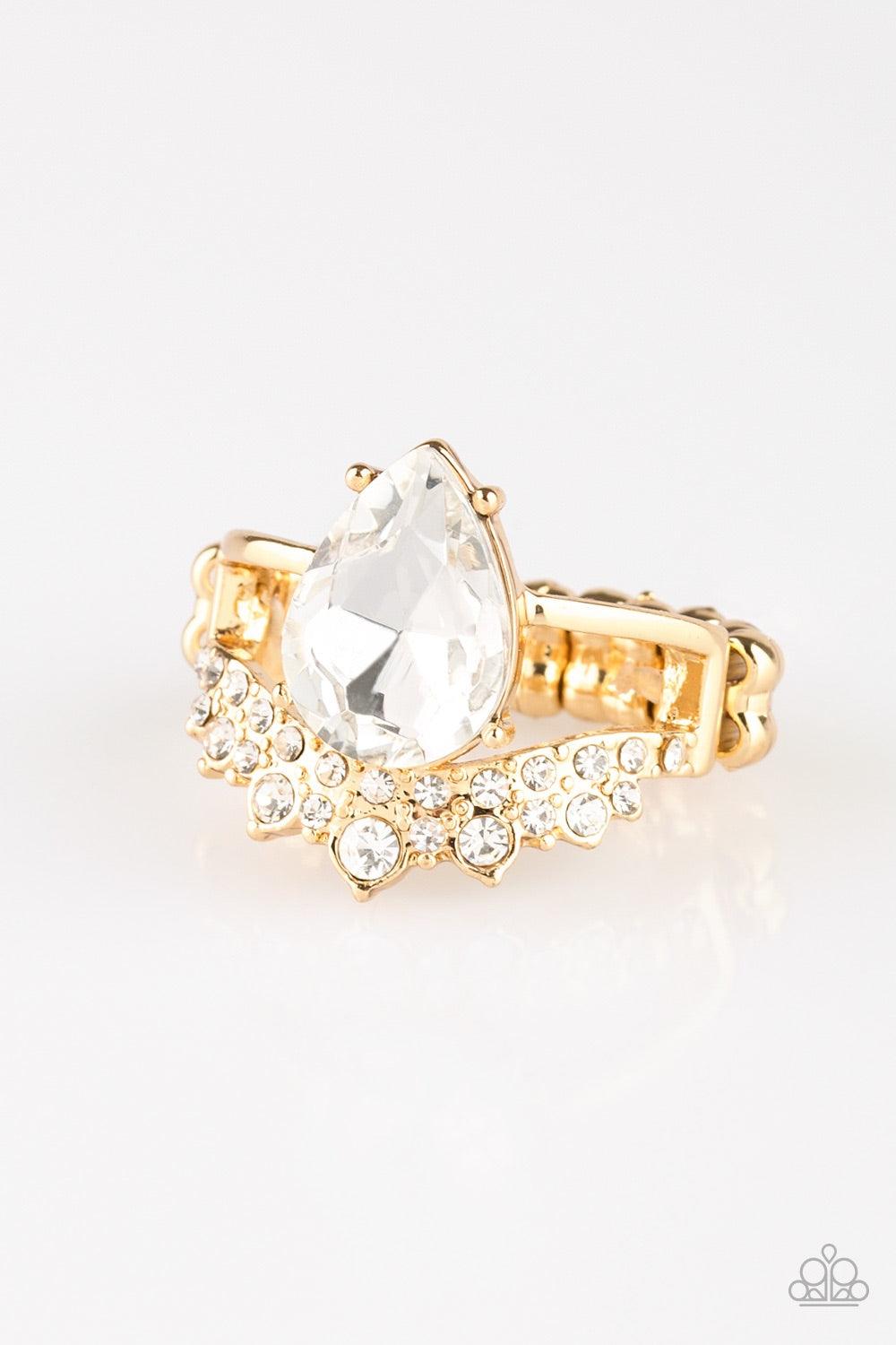Paparazzi Accessories If the Crown Fits - Gold A shiny gold bar and white rhinestone encrusted bar arc across the finger, coalescing into an airy band. Featuring a regal teardrop cut, a glittery white rhinestone is pressed into the bands for a statement m