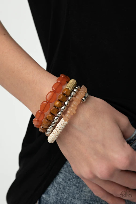 Paparazzi Accessories Outdoor Retreat - Multi An earthy collection of wooden cubes, glassy orange acrylic ovals, wavy orange accents, tranquil orange pebble-like accents, classic silver beads and silver chevron frames are threaded along a long wire to cre