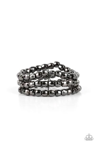 Paparazzi Accessories Magnetically Maven - Black Held together with dainty gunmetal fittings, rows of faceted gunmetal beads are threaded along stretchy bands around the wrist, coalescing into bold layers. Sold as one individual bracelet. Jewelry