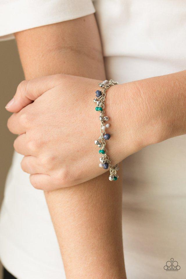 Paparazzi Accessories Aquactic Adventure - Blue A variety of faceted Arcadia, Sailor Blue, and Harbor Mist beads swing from a shimmery silver chain, creating a flirtatious fringe around the wrist. Faceted silver beads trickle between the colorful beads, a