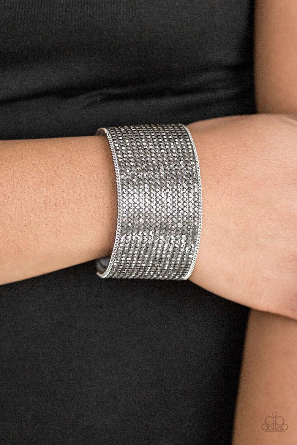 Paparazzi Accessories Glitter Gossip - Silver Row after row of glittery hematite rhinestones are encrusted along a thick gray suede band, creating blinding shimmer across the wrist. Features an adjustable snap closure. Jewelry