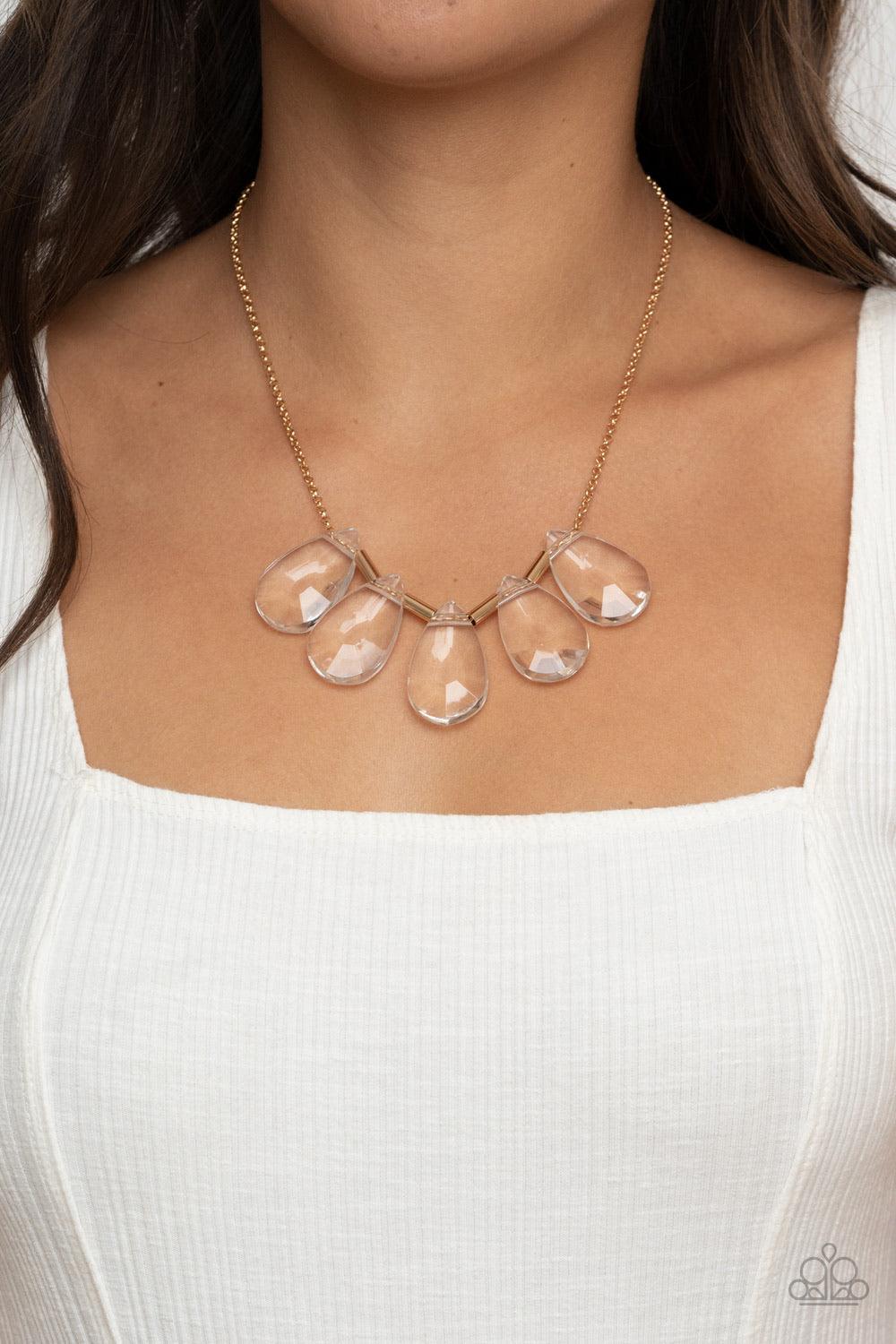 Paparazzi Accessories HEIR it Out - Gold Infused with cylindrical gold accents, a glittery collection of oversized glassy white teardrop gems slide along a dainty gold chain below the collar for a jaw-dropping finish. Features an adjustable clasp closure.