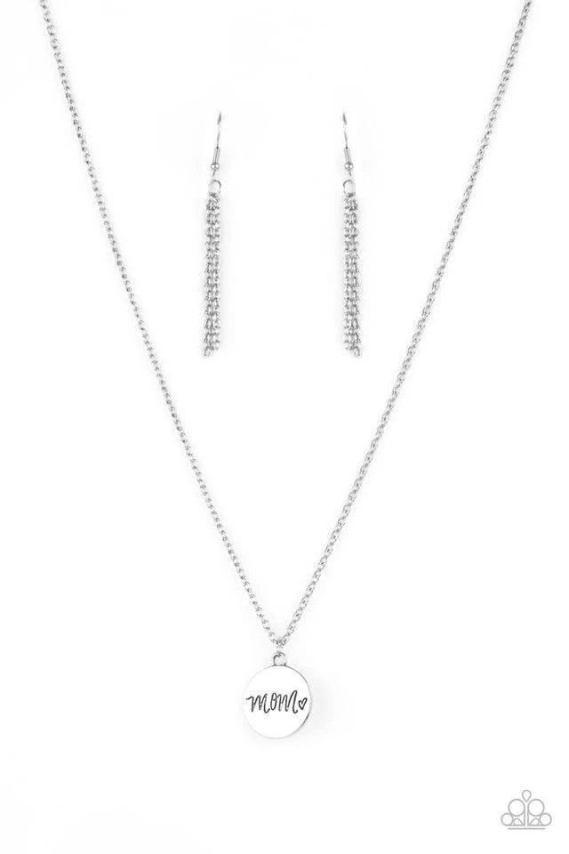Paparazzi Accessories The Cool Mom - Silver A dainty heart engraved next to the word "Mom" on a shiny silver disc creates a sweet memento as it falls below the collar. Features an adjustable clasp closure. Jewelry
