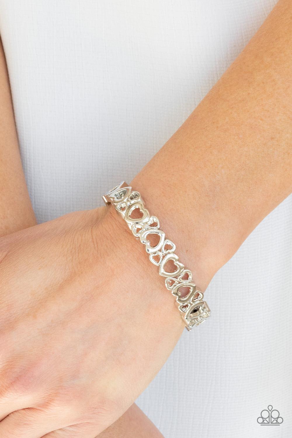 Paparazzi Accessories YOU Heart The Lady! ~Silver A charming collection of airy silver heart frames connects into a dainty bangle-like cuff around the wrist. Features a hinged closure. Sold as one individual bracelet. Bracelet