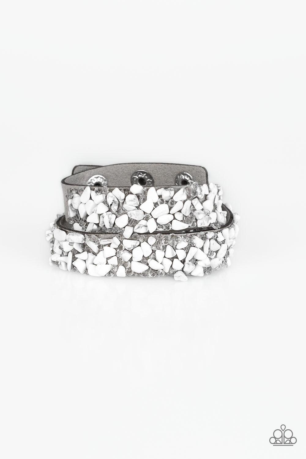 Paparazzi Accessories CRUSH to Conclusions - White A collection of crushed white rocks and glassy white rhinestone prisms are sprinkled across a gray suede band for a seasonal look. The elongated band allows for a trendy double wrap design. Features an ad