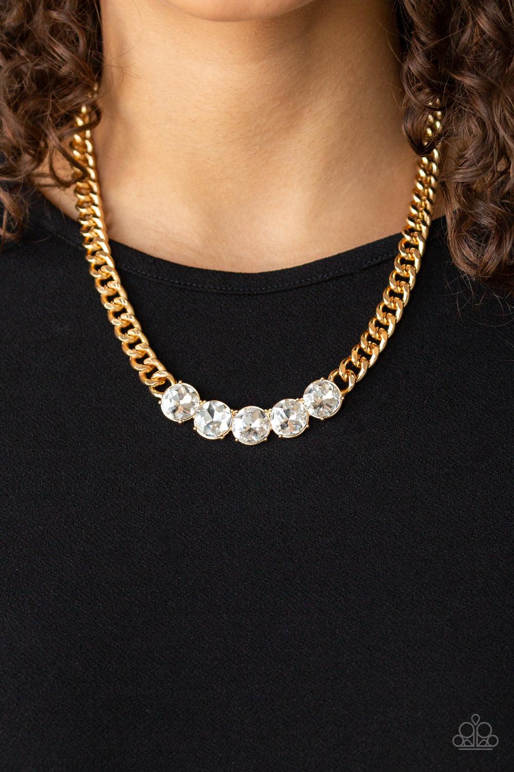 Paparazzi Accessories Rhinestone Renegade - Gold A thick gold chain gives way to a dramatic row of glittery white rhinestones, creating a bold and blinding statement below the collar. Features an adjustable clasp closure. Jewelry