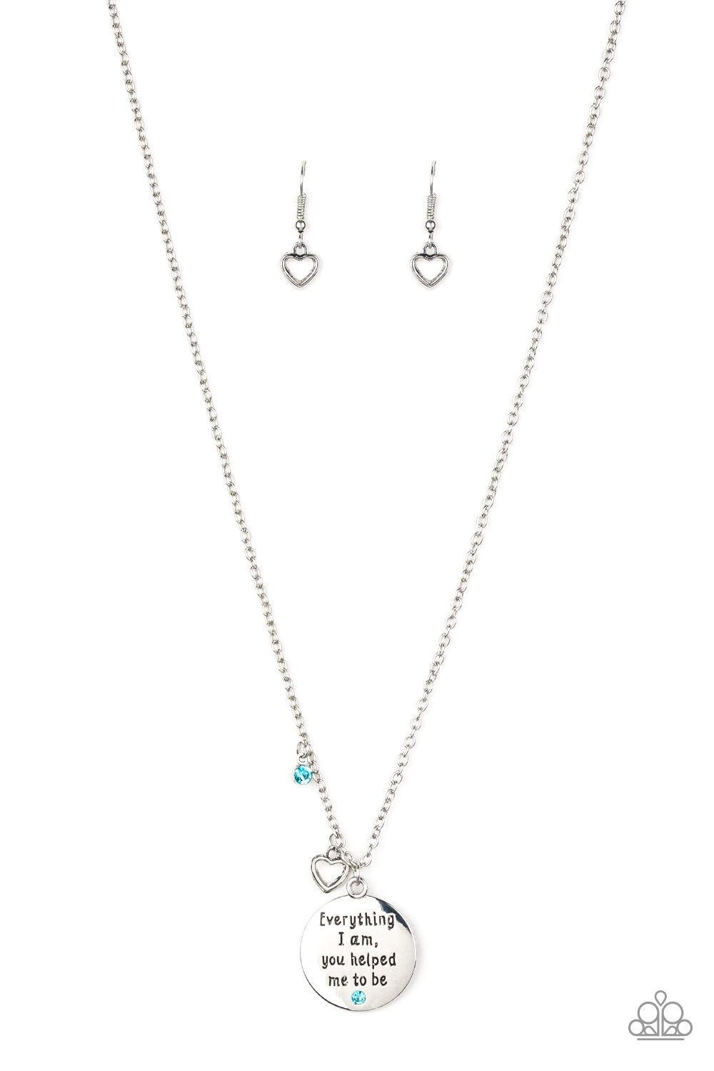 Paparazzi Accessories Everything I Am - Blue A solitaire blue rhinestone, dainty silver heart, and a shimmery silver disc stamped with the inspirational phrase, "Everything I am, you helped me be", swings below the collar for a whimsical look. Features an