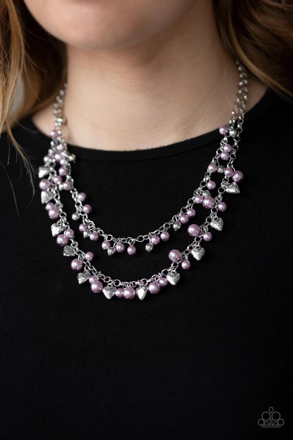 Paparazzi Accessories Kindhearted Heart - Purple A collection of shiny silver beads and pearly purple beads cascade from the bottoms of two layered silver chains. Stamped in the word, "Love" floral heart charms dangle from the lowermost chain, creating a