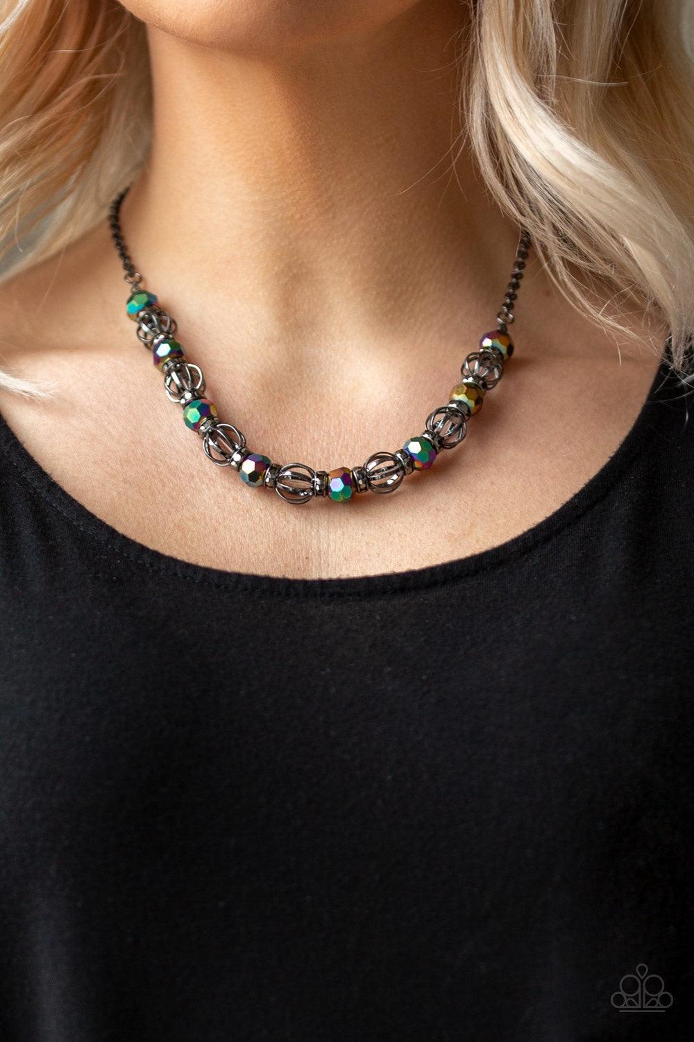 Paparazzi Accessories Metro Majestic - Multi A collection of airy gunmetal beads, faceted rainbow metallic beads, and hematite rhinestone encrusted rings are threaded along an invisible wire below the collar for a statement-making fashion. Features an adj