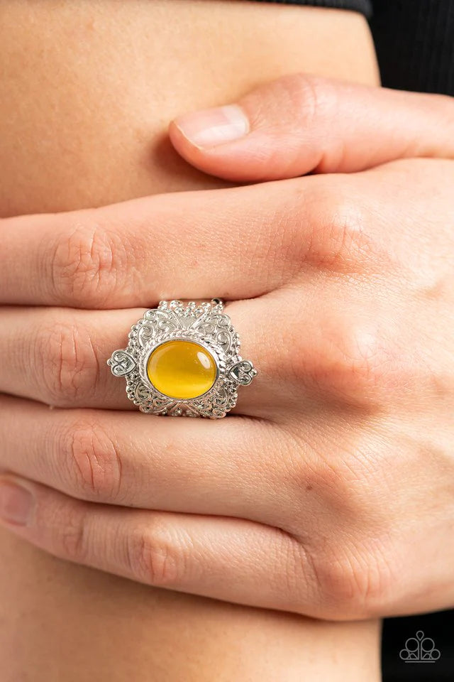 Paparazzi Accessories Delightfully Dreamy - Yellow Embossed in an enchanting heart motif, a frilly silver frame is adorned with a dreamy yellow cat's eye stone center for a magical pop of color atop the finger. Features a stretchy band for a flexible fit.