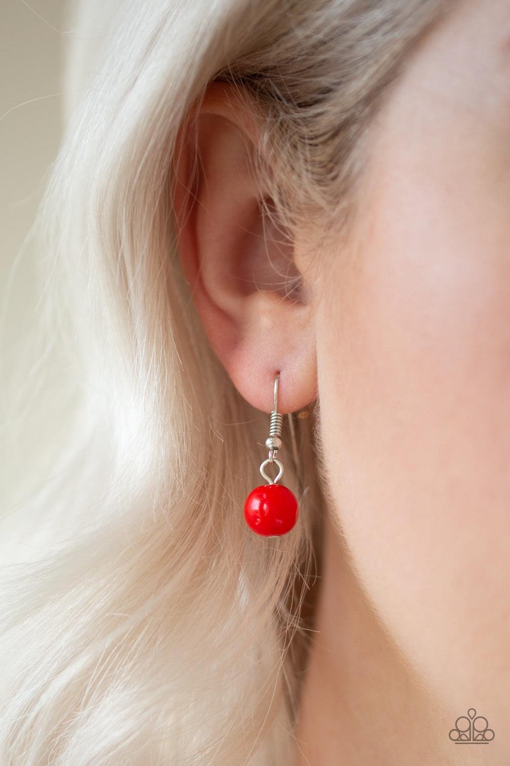 Paparazzi Accessories Everyday Eye Candy - Red Infused with metallic accents, fiery red beads gradually increase in size as they are threaded along an invisible wire below the collar for a vibrant pop of color. Features an adjustable clasp closure. Jewelr