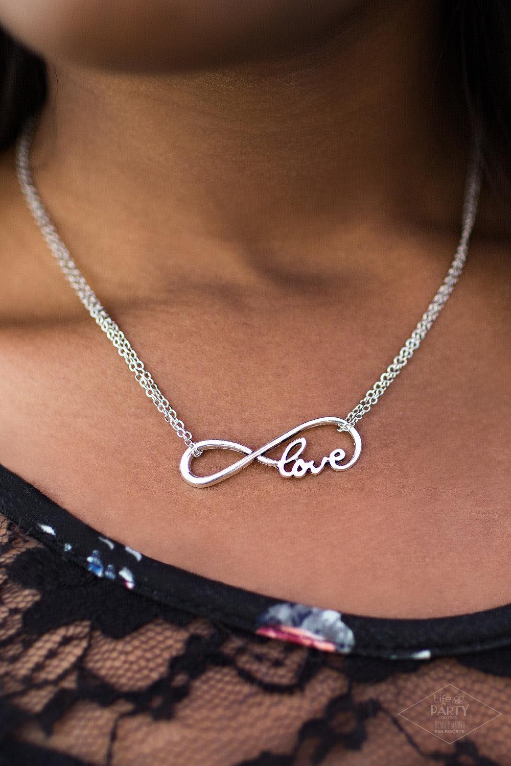 Paparazzi Accessories We Found Love ~White A dainty silver infinity charm swoops below the collar, spelling out the word “Love” in its bottom corner. Dainty silver chains loop around the airy charm, completing the delicate design. Features an adjustable c