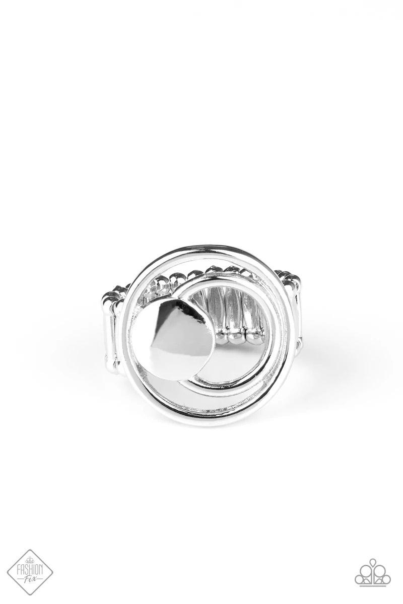 Paparazzi Accessories Edgy Eclipse - Silver A solid silver disc and airy silver hoops eclipse across the finger, delicately coalescing into an edgy offset frame. Features a stretchy band for a flexible fit. Sold as one individual ring. Jewelry
