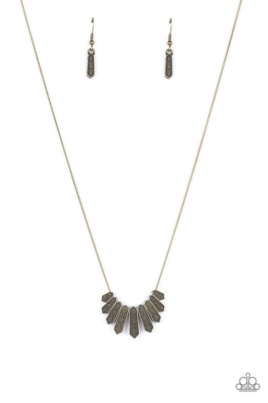Paparazzi Accessories Monumental March - Brass A row of brass obelisk-like monuments gradually decrease in size as they fan out across the collar. Delicately embossed with textured diamond shapes, they march along a dainty round brass chain. Features an a
