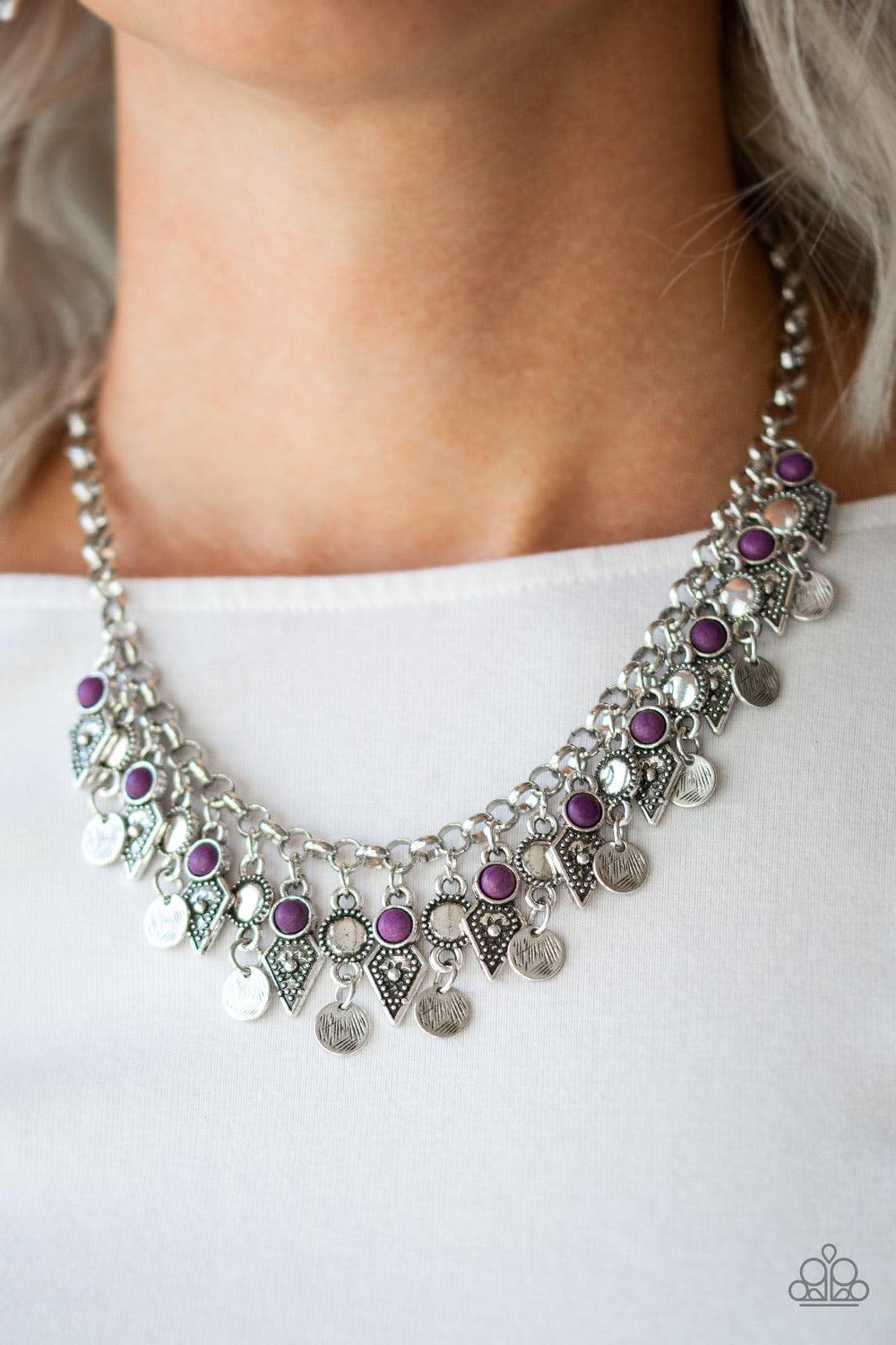 Paparazzi Accessories Jurassic Jamboree - Purple Featuring glassy and polished finishes, round and asymmetrical purple beads trickle from the bottom of a double-linked silver chain. An additional silver chain is layered above the summery beading for a sea