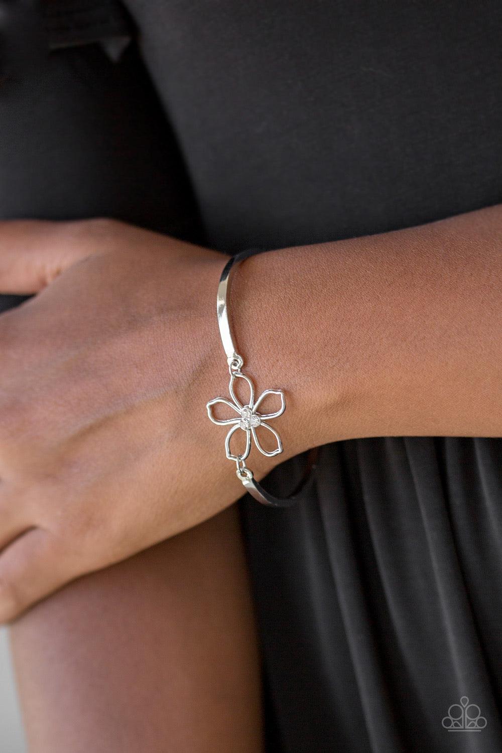 Paparazzi Accessories Hibiscus Hipster - White Dotted with a radiant white rhinestone center, an airy silver floral frame attaches to two shiny silver bars, creating a whimsical centerpiece atop the wrist. Features an adjustable clasp closure. Sold as one