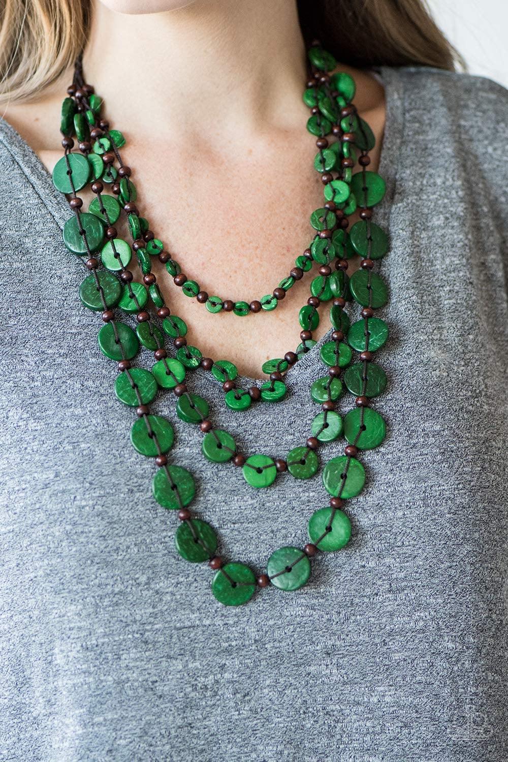Paparazzi Accessories Fiji Flair - Green Tinted in an iridescent finish, green wooden discs and brown beads are knotted into four summery strands below the collar. The colorful accents gradually increase in size, adding depth to the layered look. Features