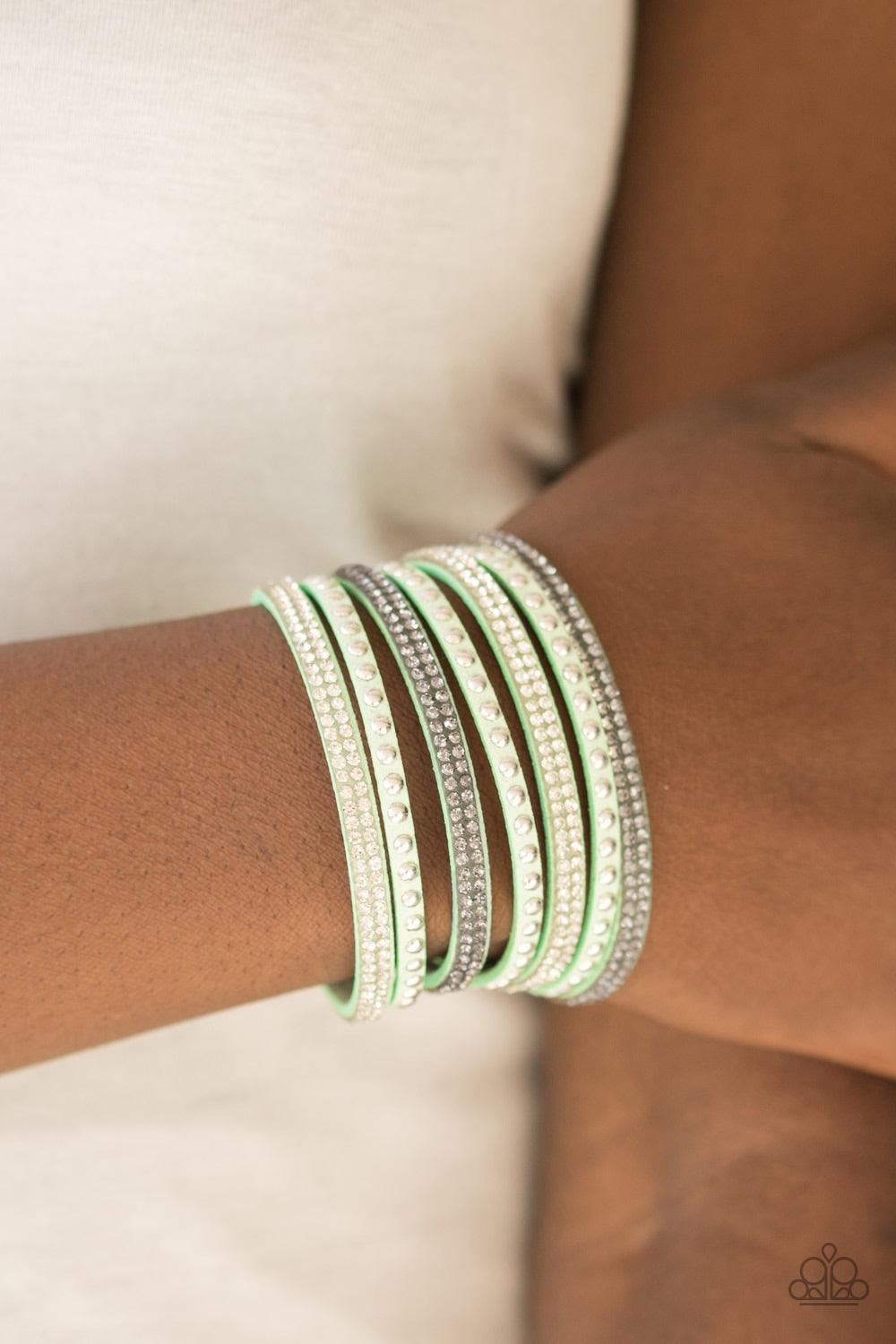 Paparazzi Accessories Victory Shine - Green Shiny silver studs and rows of smoky and glittery white rhinestones are encrusted along strips of green suede, creating sassy shimmer around the wrist. Features an adjustable snap closure. Jewelry