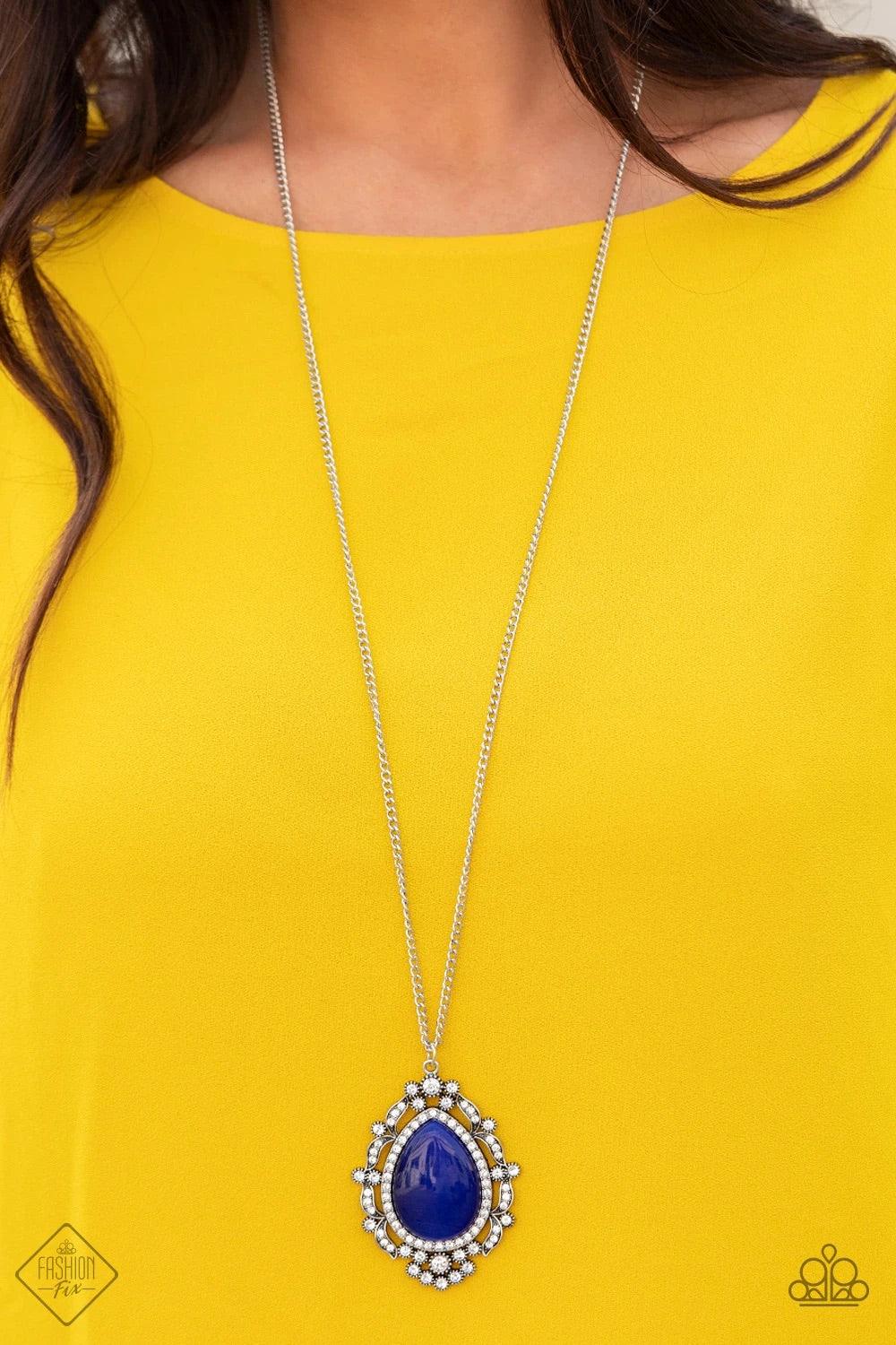 Paparazzi Accessories Frozen Gardens ~Blue Dotted in glittery white rhinestones, leafy silver frames nestle around a glowing Classic Blue cat's eye teardrop center, creating a regal pendant at the bottom of a lengthened silver chain. Features an adjustabl