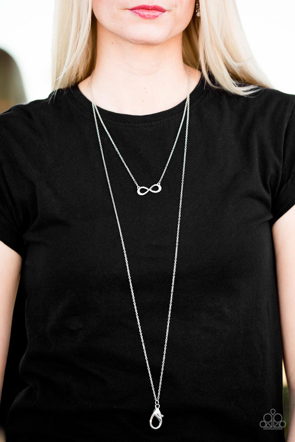 Paparazzi Accessories Forever Glamorous - White *Lanyard Encrusted in sections of glittery white rhinestones, a dainty silver ribbon swirls into a glistening infinity charm below the collar in a timeless fashion. A lobster clasp hangs from the bottom of t
