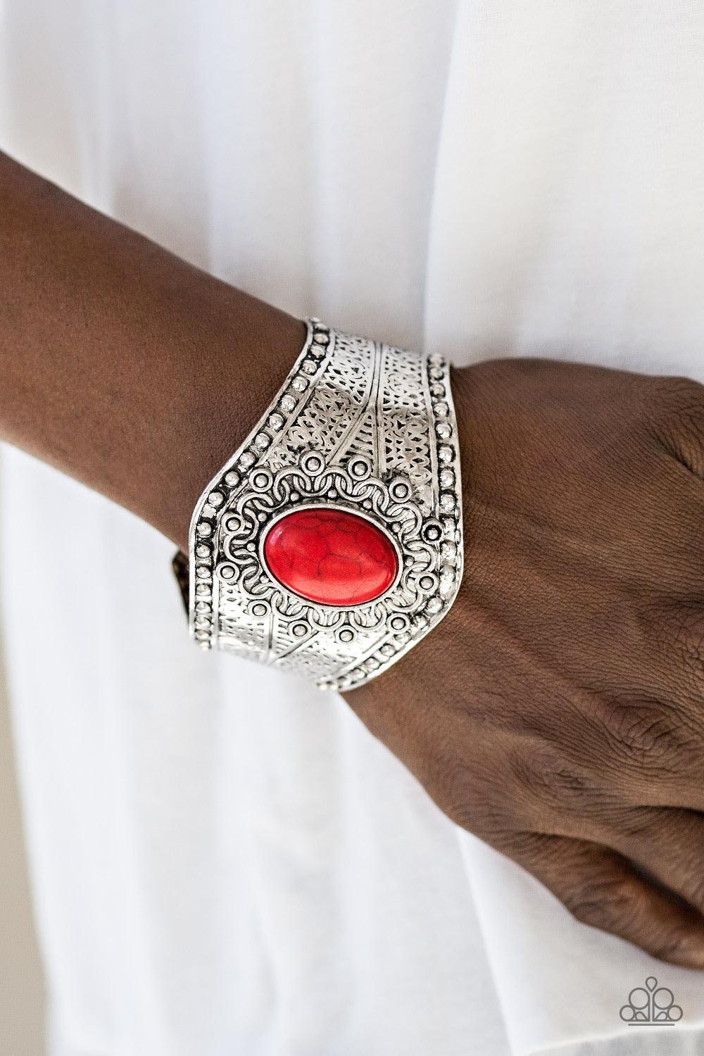 Paparazzi Accessories Mojave Majesty - Red Delicately hammered and studded in tribal inspired textures, a thick silver cuff wraps around the wrist in an artisan inspired fashion. A smooth red stone is pressed into the middle of a silver sunburst pattern,