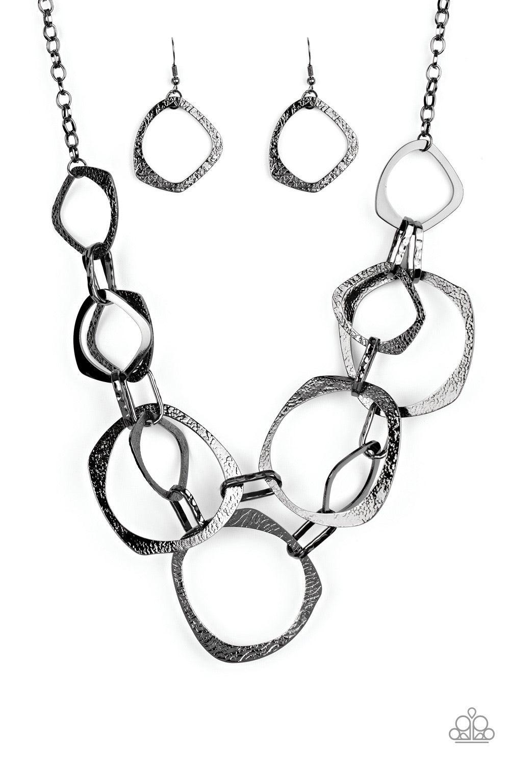 Paparazzi Accessories Salvage Yard ~Black Salvage Yard - Black P2ST-BKXX-112XX Hammered in shimmery detail, oversized asymmetrical gunmetal rings and gritty gunmetal links boldly link below the collar in two dramatic rows for a sassy industrial look. Feat