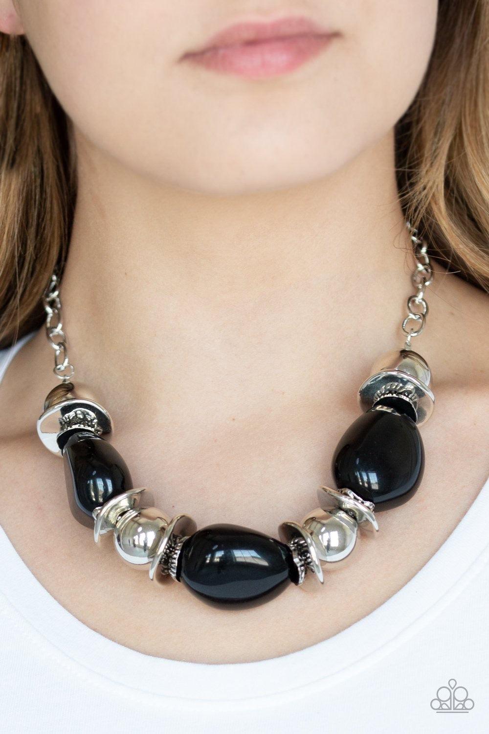 Paparazzi Accessories Vivid Vibes ~Black A collection of over sized black beads, shiny silver beads, and beveled silver discs are threaded along an invisible wire below the collar for a vivacious look. Features an adjustable clasp closure.