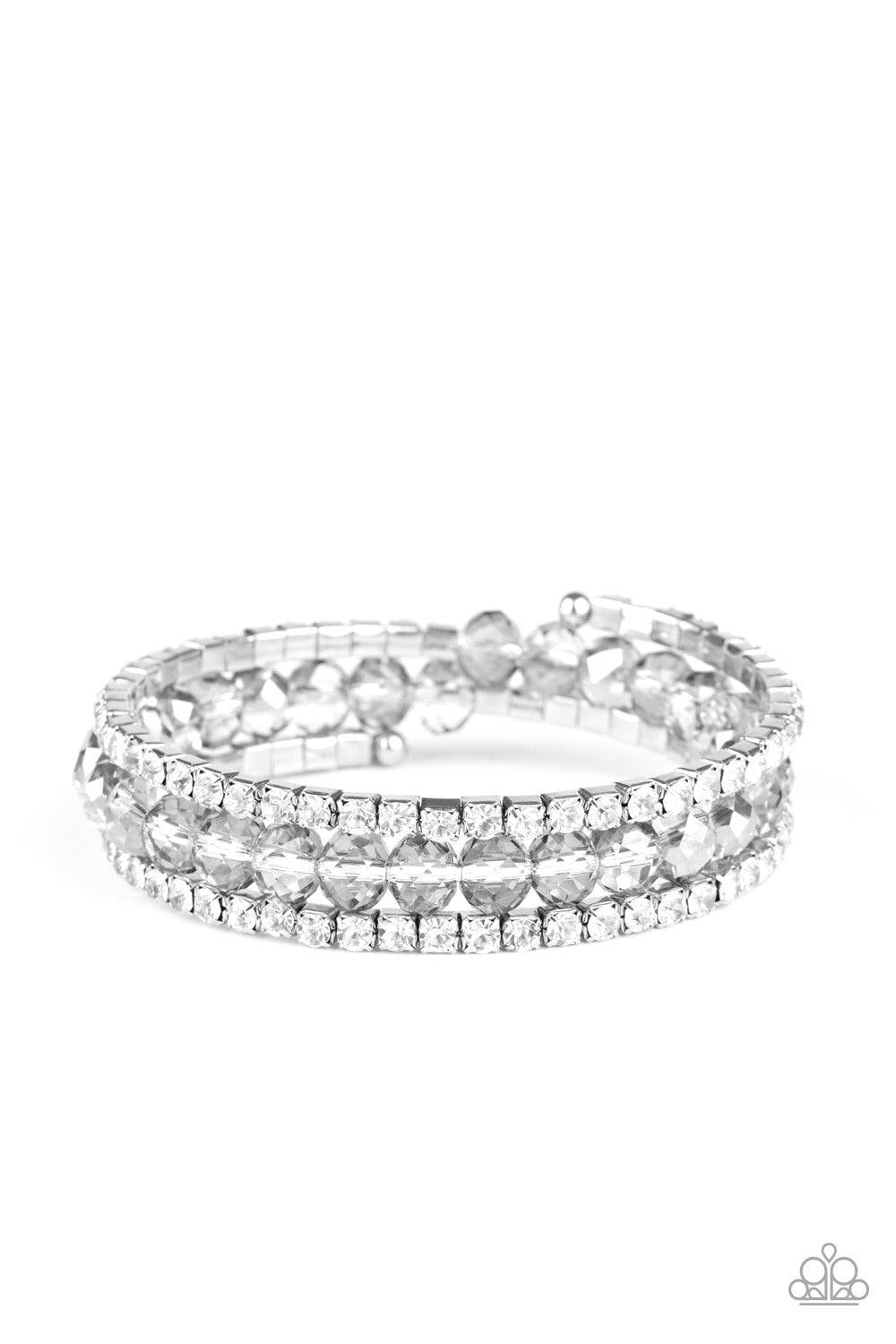 Paparazzi Accessories Glam-ified Fashion - Silver A refined collection of white rhinestone encrusted frames and smoky crystal-like beads are threaded along a coiled wire, creating a timeless infinity wrap style bracelet around the wrist. Sold as one indiv
