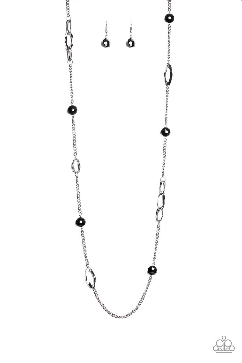 Paparazzi Accessories Duchess Dazzle - Black A collection of black rhinestone gems and abstract gunmetal rings trickle along a classic gunmetal chain across the chest for a refined flair. Features an adjustable clasp closure. Sold as one individual neckla