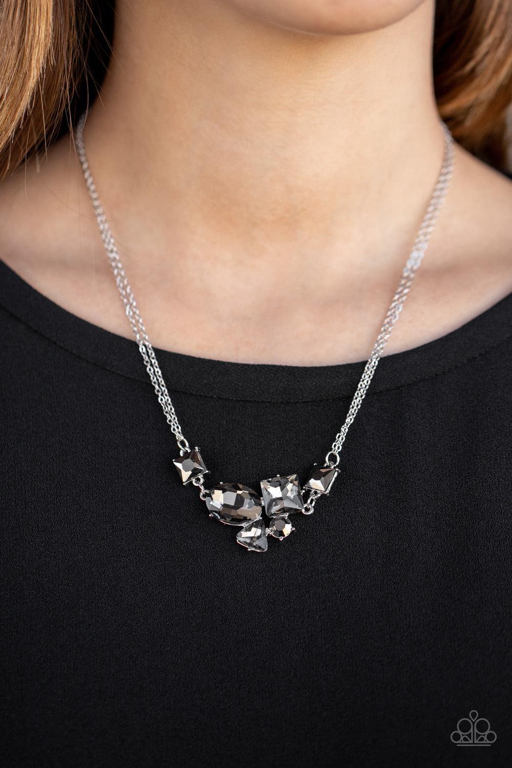Paparazzi Accessories Constellation Collection - Silver Varying in shape and size, triangular, round, and square cut hematite and smoky rhinestones coalesce into a floating pendant at the bottom of doubled silver chains, creating a stellar shimmer below t