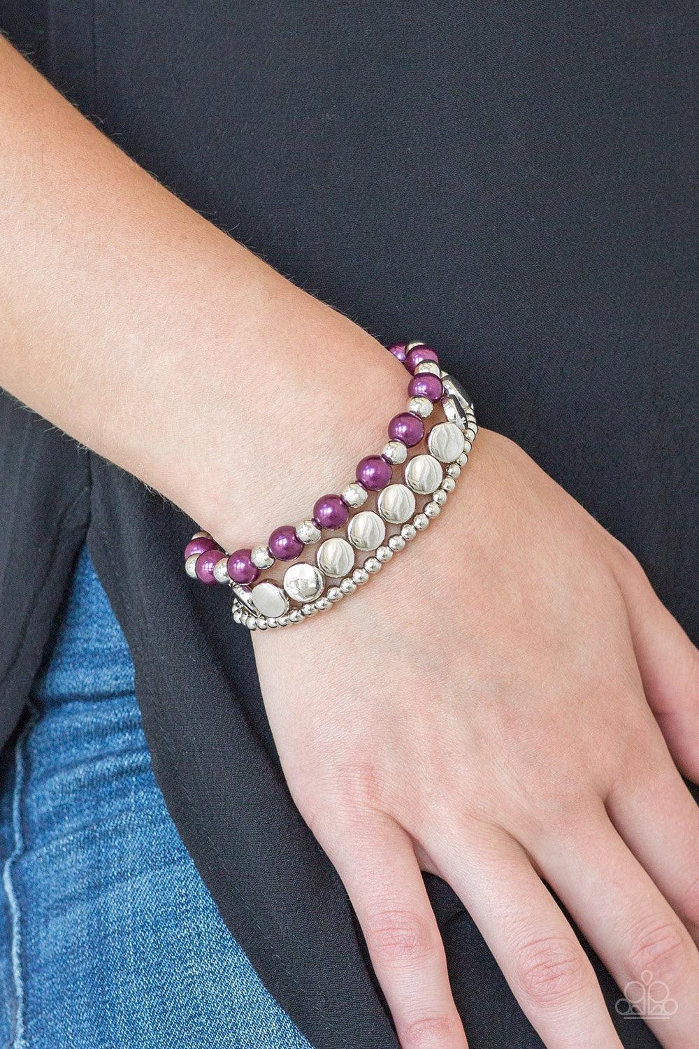 Paparazzi Accessories Girly Girl Glamour - Purple Mismatched silver and pearly purple beads are threaded along stretchy elastic bands, creating colorful layers across the wrist. Jewelry