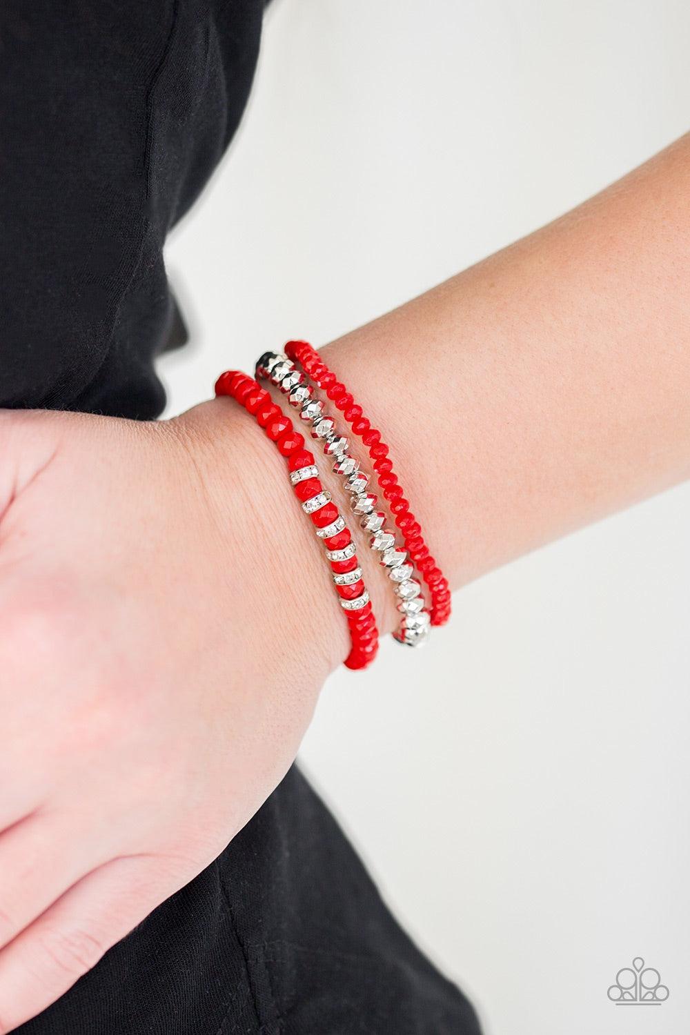 Paparazzi Accessories Ideal Idol - Red A collection of faceted red and silver beads are threaded along stretchy bands around the wrist. White rhinestone encrusted rings are added to one strand for a refined finish. Jewelry
