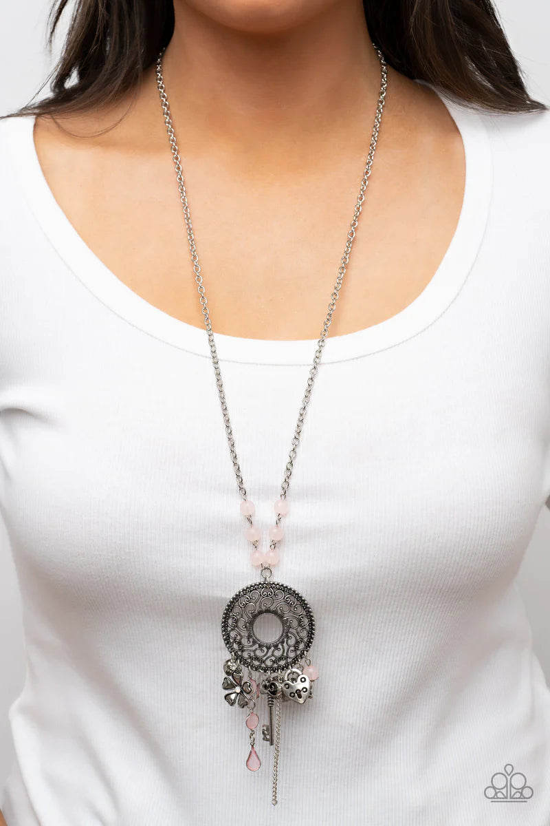 Paparazzi Accessories Making Memories - Pink Infused with glassy Pale Rosette beaded accents, a whimsical assortment of silver key, heart, and floral charms cascades from an oversized studded silver frame that whirls with heart shaped vine-like filigree.