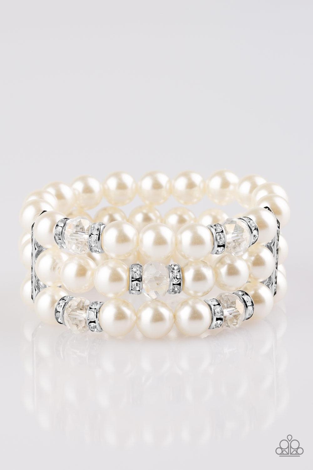 Paparazzi Accessories Undeniably Dapper - White Pinched between white rhinestone encrusted frames, white rhinestone encrusted rings, crystal-beads, and white pearls are threaded along elastic stretchy bands for a glamorous look. Jewelry