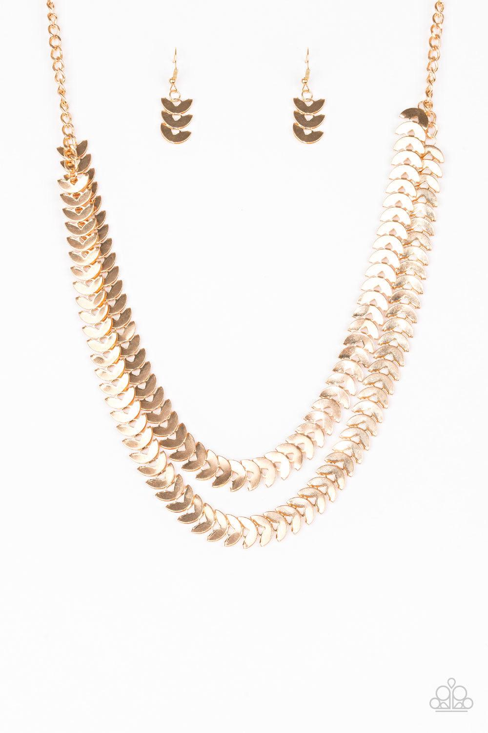 Paparazzi Accessories Industrial Illumination - Gold Glistening gold discs are folded in half and linked into two shimmery layers across the chest for an edgy industrial look. Features an adjustable clasp closure. Sold as one individual necklace. Includes