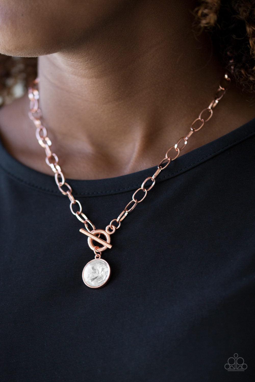 Paparazzi Accessories She Sparkles On - Copper A dramatic white gem swings from the bottom of a shiny copper chain, creating a blinding pendant below the collar. Features a toggle closure. Jewelry
