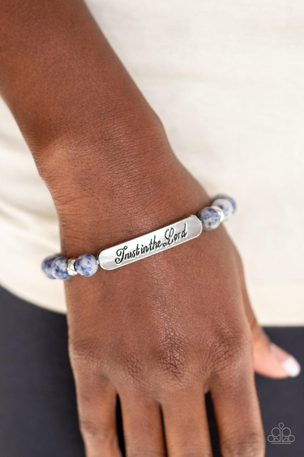 Paparazzi Accessories Keep The Trust - Blue Infused with dainty silver accents, a collection of glassy blue stone beads and a shimmery silver frame stamped in the phrase, "Trust in the Lord", are threaded along a stretchy band around the wrist for an insp