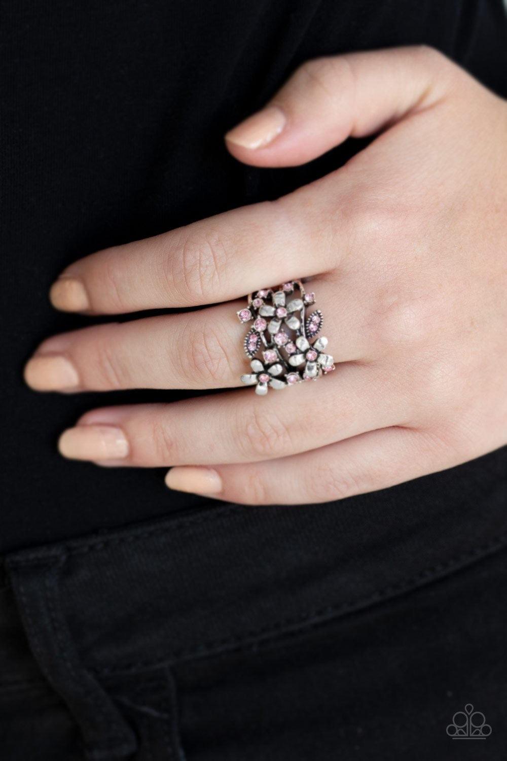 Paparazzi Accessories Gardenia Gleam - Pink Dotted with glittery pink rhinestones, a trio of shimmery silver flowers bloom across the finger, coalescing into a whimsical band. Features a stretchy band for a flexible fit. Jewelry