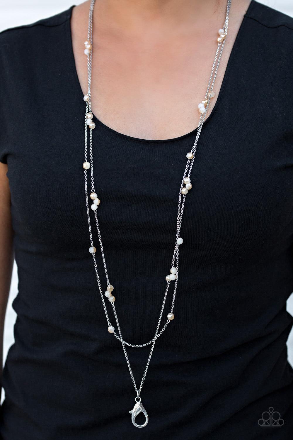 Paparazzi Accessories Swag and Sparkle - Brown *Lanyard Opaque crystal-like beads trickle along two strands of shimmery silver chain, creating glittery accents across the chest. A lobster clasp hangs from the bottom of the design to allow a name badge or