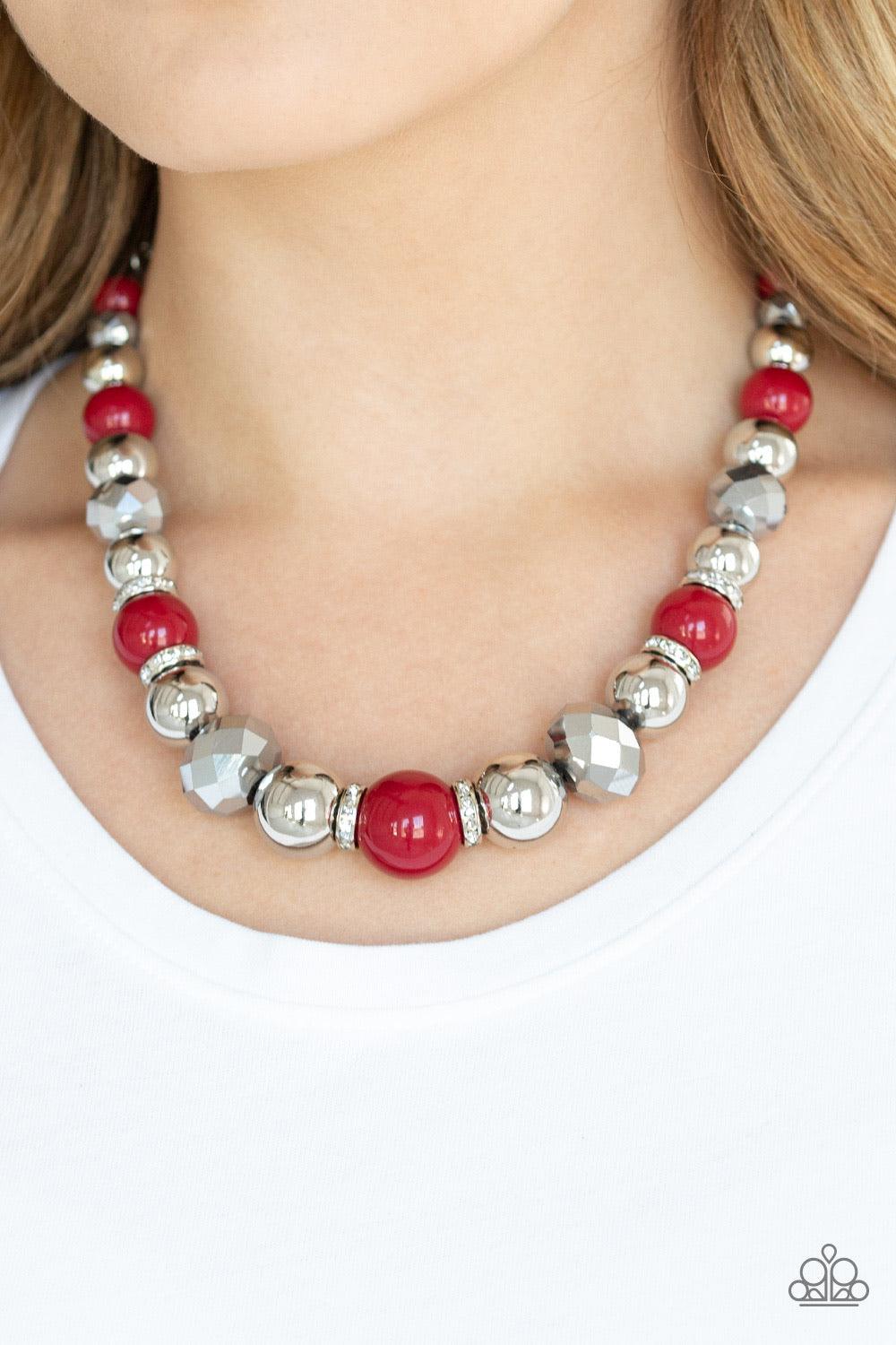 Paparazzi Accessories Weekend Party ~Red A collection of oversized silver beads, robust Samba beads, white rhinestone encrusted rings, and metallic crystal-like beads are threaded along an invisible wire below the collar for a glamorous statement-making f