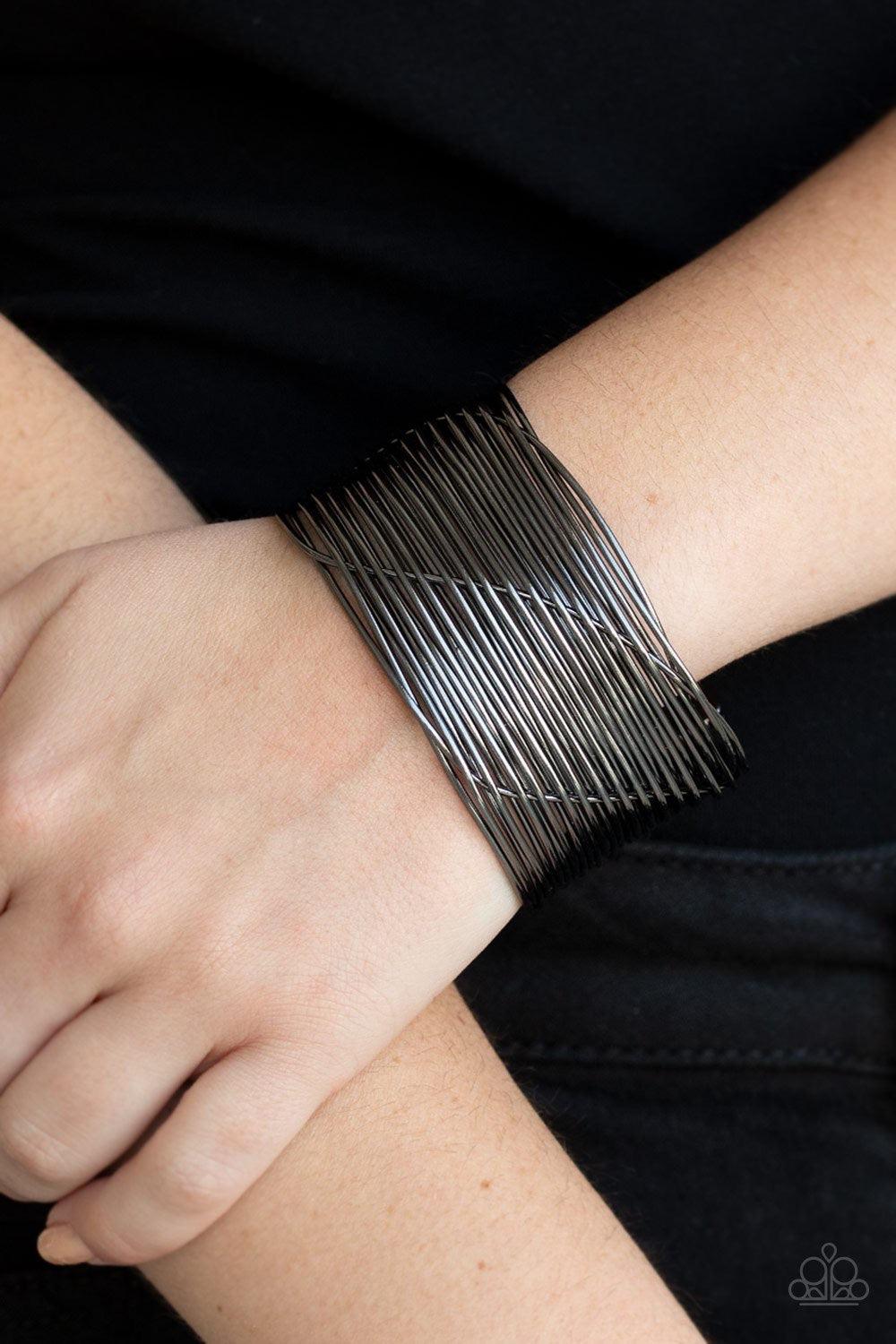 Paparazzi Accessories Retro Revamp - Black A glistening gunmetal wire weaves through stacked gunmetal bars arcing across the wrist, coalescing into an edgy cuff. Jewelry