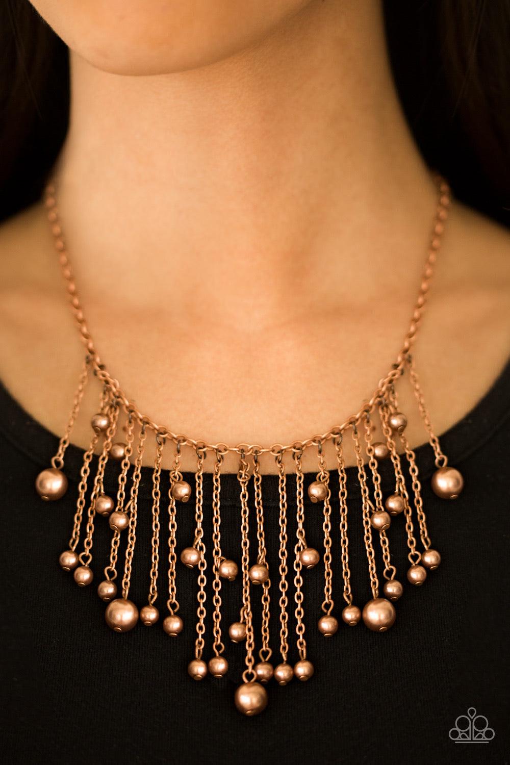 Paparazzi Accessories Catwalk Champ - Copper Varying in length, glistening copper chains swing from the bottom of a bold copper chain. Pearly copper beads trickle down the chains, creating a fierce fringe below the collar. Features an adjustable clasp clo